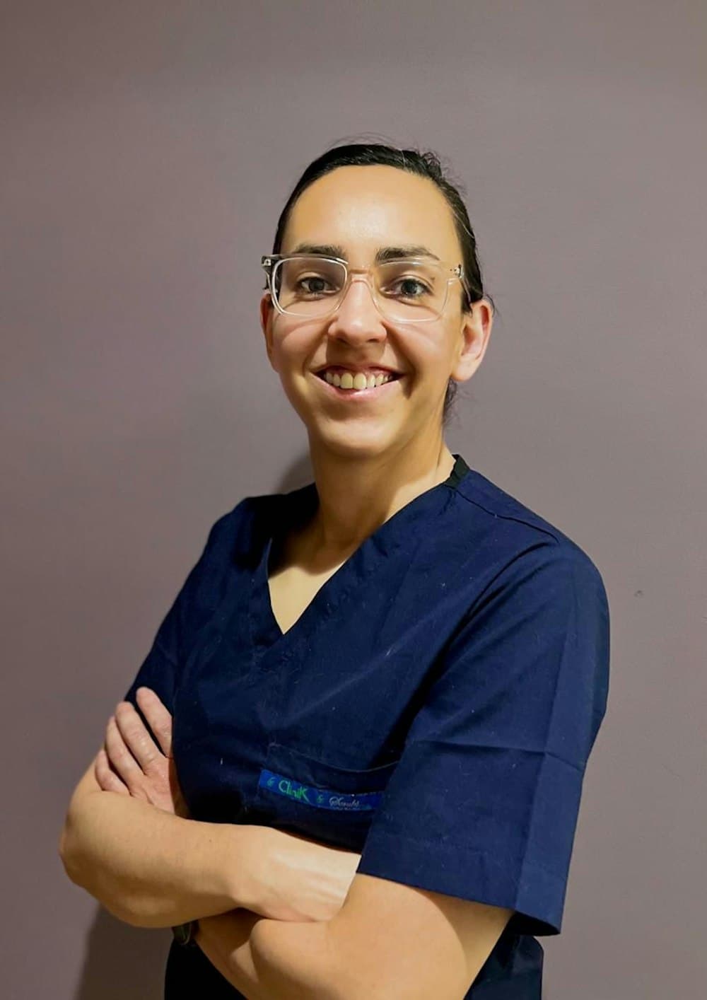A smiling caregiver in navy scrubs
